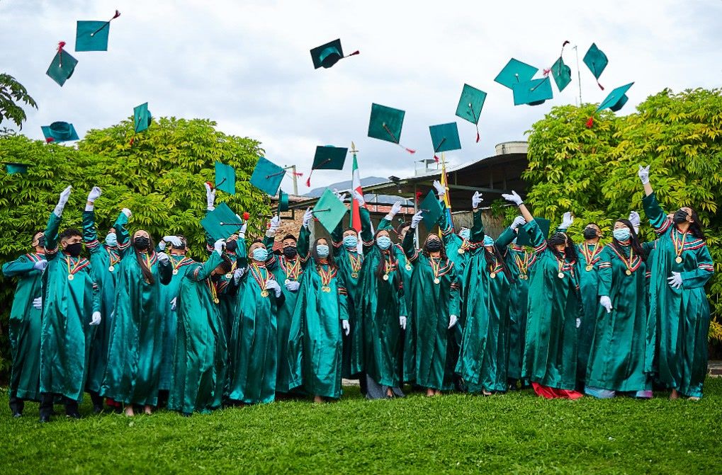 Egresados de COLREY lanzando sus birretes el día de su graduación
