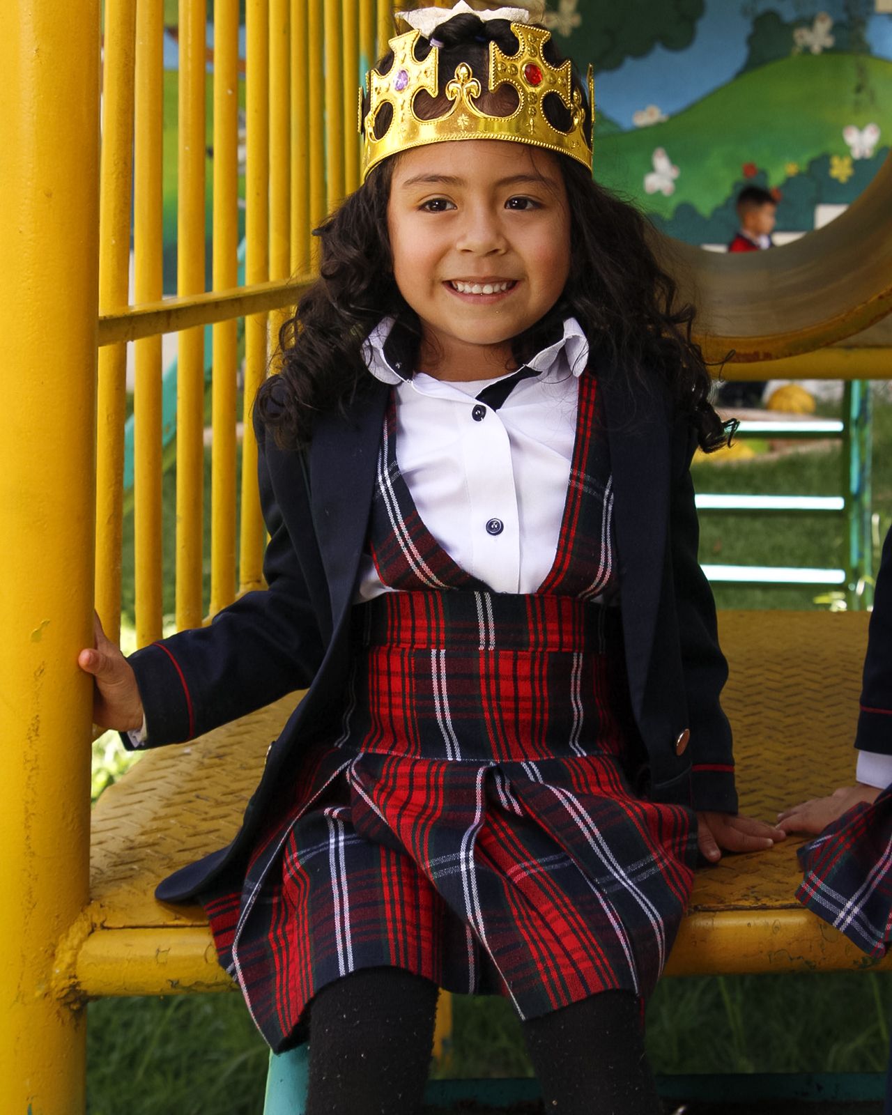 Estudiante de primaria con el uniforme de COLREY sonriendo en el parque